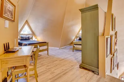 a room with a table and a refrigerator and a bedroom at Star House Unique Home with 360 Mountain Views! in Pine Mountain Club