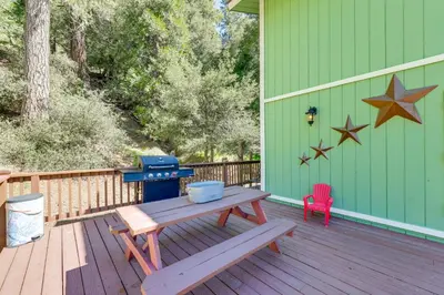 a wooden deck with a picnic table and a grill at Remodeled Crestline Retreat Walk to Lake Gregory! in Crestline