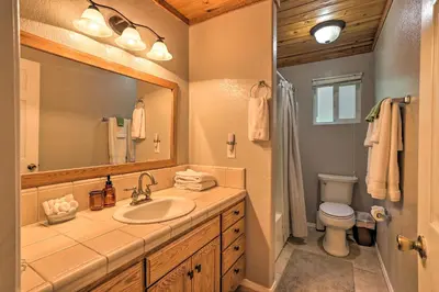 a bathroom with a sink and a toilet and a mirror at Remodeled Crestline Retreat Walk to Lake Gregory! in Crestline