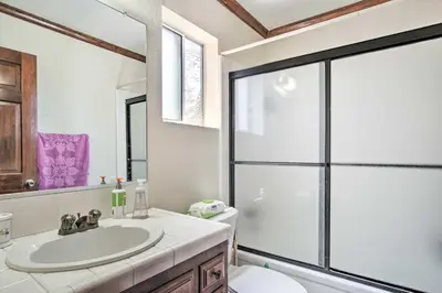 a bathroom with a sink and a glass shower at 5 Mi to Lake Arrowhead Village Cabin with Game Room in Lake Arrowhead