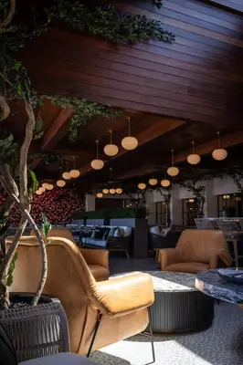 a lobby with chairs and tables and lights at Palm Garden Hotel in Thousand Oaks