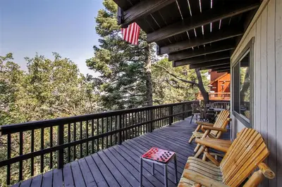 a porch with two chairs and an american flag at Family Cabin with Game Room Near Hiking and Skiing! in Lake Arrowhead