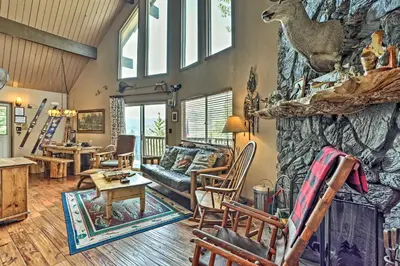 a living room filled with furniture and a stone wall at Family Cabin with Game Room Near Hiking and Skiing! in Lake Arrowhead