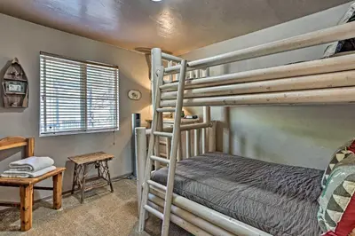a bedroom with two bunk beds and a table at Family Cabin with Game Room Near Hiking and Skiing! in Lake Arrowhead