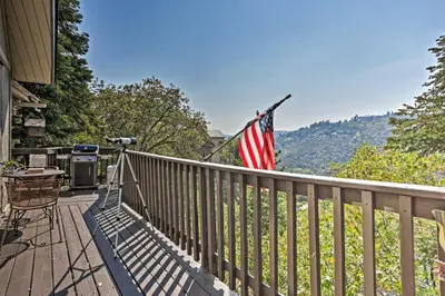 a porch with an american flag on a fence at Family Cabin with Game Room Near Hiking and Skiing! in Lake Arrowhead