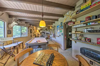 a room with a table and a pool table at Family Cabin with Game Room Near Hiking and Skiing! in Lake Arrowhead