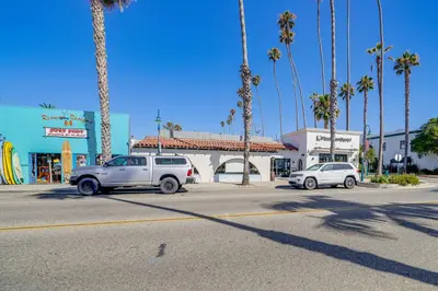 two cars parked in a parking lot with palm trees at Victorian Carpinteria Apartment Less Than 1 Mi to Beach! in Carpinteria