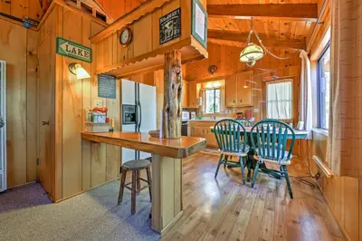 a kitchen and dining room with a table and chairs at Big Bear Lake Cabin with Deck about 7 Mi to Ski Slopes! in Fawnskin