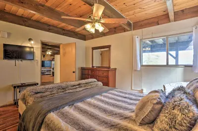 a bedroom with a bed and a ceiling fan at A-Frame Home with 3 Decks and Lake Arrowhead Views! in Lake Arrowhead
