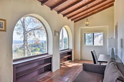 a living room with a couch and two windows at The Castle Hacienda Heights Home with Patio and Pool in Hacienda Heights