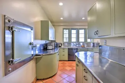 a large kitchen with white cabinets and a tile floor at The Castle Hacienda Heights Home with Patio and Pool in Hacienda Heights