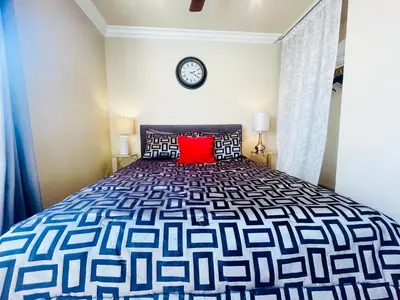 a bedroom with a large bed with a red pillow at GREAT FOR BUSINESS & FAMILY TRIPS 3BD 2BA close to DESNEYLAND, FREE PARKING in Orange