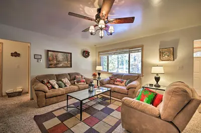 a living room with couches and a ceiling fan at Walk to Lake Rustic Home with Deck in Fawnskin in Fawnskin