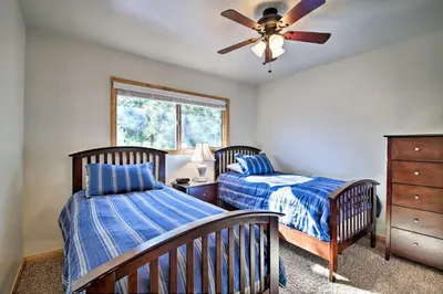 a bedroom with two beds and a ceiling fan at Walk to Lake Rustic Home with Deck in Fawnskin in Fawnskin
