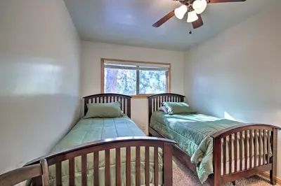 a bedroom with two beds and a ceiling fan at Walk to Lake Rustic Home with Deck in Fawnskin in Fawnskin