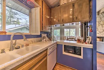 a kitchen with a sink and a large window at Lake Arrowhead Cabin with Deck and Scenic Forest Views in Lake Arrowhead