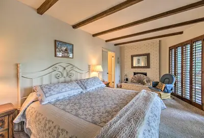 a bedroom with a large bed and a fireplace at Lake Arrowhead Cabin with Deck and Scenic Forest Views in Lake Arrowhead