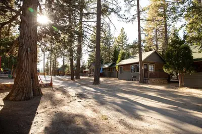 a park with a house and trees and a bench at Juniper Lakeside Couples Resort Cabin by Big Bear Vacations in Big Bear Lake
