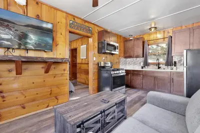 a kitchen with wood paneling and a table in a room at Juniper Lakeside Couples Resort Cabin by Big Bear Vacations in Big Bear Lake