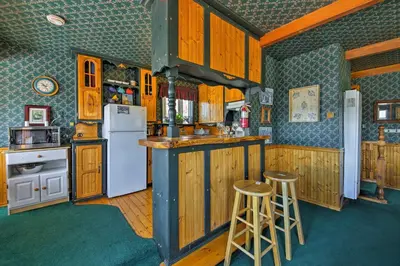 a kitchen with wooden cabinets and a white refrigerator at Walk to Lake Cabin with Deck and Views in Fawnskin in Fawnskin