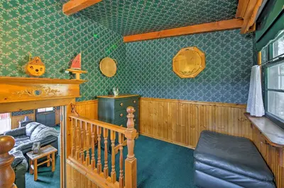 a room with a bed and a crib in a room at Walk to Lake Cabin with Deck and Views in Fawnskin in Fawnskin