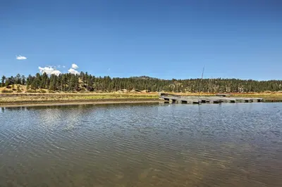 a lake with a dock in the middle of it at Walk to Lake Cabin with Deck and Views in Fawnskin in Fawnskin