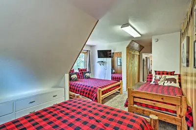 a bedroom with two beds with red and blue at Expansive Retreat with Deck, Game Room and Lake Views! in Lake Arrowhead