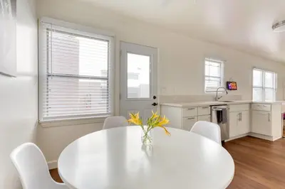 a white dining room with a white table and chairs at New Beach Jewel Bungalow in Long Beach