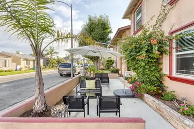 a patio with chairs and an umbrella on a street at New Beach Jewel Bungalow in Long Beach