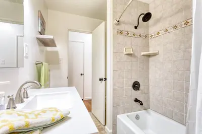 a white bathroom with a sink and a shower at New Beach Jewel Bungalow in Long Beach