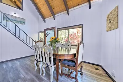 a dining room with a wooden table and chairs at Bikes and Game Room Lovely Lake Arrowhead Home! in Lake Arrowhead