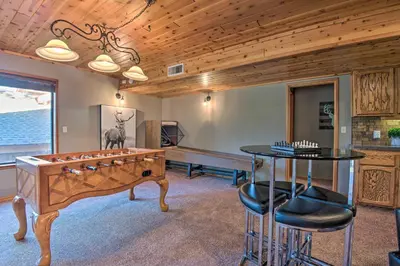 a game room with a foosball table and a bench at Spacious Pine Mtn Club Cabin with Game Room and Deck in Pine Mountain Club