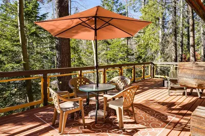 a patio with a table and chairs and an umbrella at Sequoia Forest Remote Retreat! Dreamtime Cabin in Ponderosa