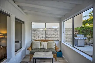 a screened in porch with a chair and a table at Remodeled Ventura Beach Home with Yard and Fire Pit! in Ventura