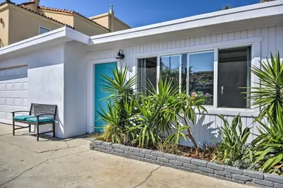 a white house with a blue door and a bench at Remodeled Ventura Beach Home with Yard and Fire Pit! in Ventura