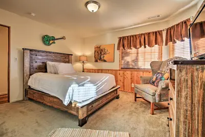 a bedroom with a bed and a chair at Hot Tub, Game Room and 2 Decks Luxe Big Bear Home in Big Bear Lake
