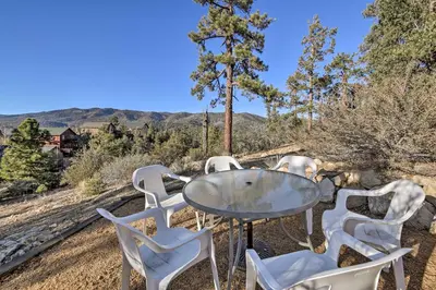 a table and chairs on a patio with mountains in the background at Hot Tub, Game Room and 2 Decks Luxe Big Bear Home in Big Bear Lake