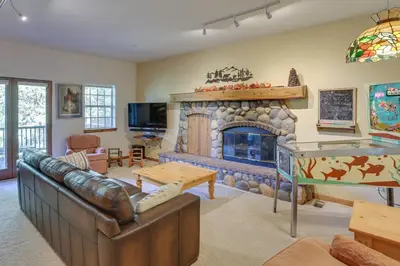 a living room with a fireplace and a couch at Luxe Lake Arrowhead Home with Deck, 3 Mi to Village! in Lake Arrowhead