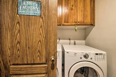 a laundry room with a washing machine and a wooden door at Luxe Lake Arrowhead Home with Deck, 3 Mi to Village! in Lake Arrowhead