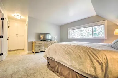 a bedroom with a bed and a tv and a window at Gorgeous Lake Arrowhead Retreat Game Room and Deck in Lake Arrowhead