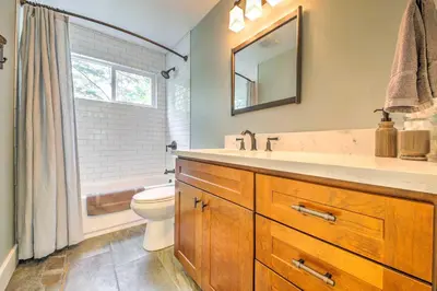 a bathroom with a sink and a toilet and a mirror at Gorgeous Lake Arrowhead Retreat Game Room and Deck in Lake Arrowhead