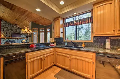a kitchen with wooden cabinets and a large window at Hike, Ski, Fish Big Bear Lake Lodge with Deck in Big Bear Lake