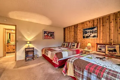 two beds in a room with wooden walls at Hike, Ski, Fish Big Bear Lake Lodge with Deck in Big Bear Lake