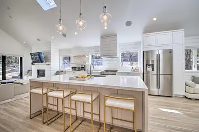 a kitchen with a large white island with bar stools at Half-Mi to Big Bear Lake Modern Home with Deck in Big Bear Lake