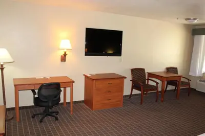 a hotel room with a desk and chairs and a television at Cajon Pass Inn in Cajon Junction
