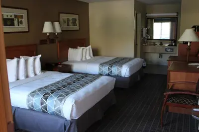 a hotel room with two beds and a desk at Cajon Pass Inn in Cajon Junction