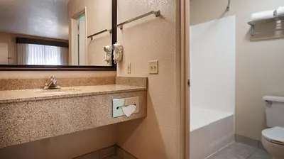 a bathroom with a sink and a toilet and a mirror at Cajon Pass Inn in Cajon Junction