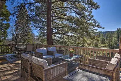 a patio with chairs and a table on a deck at Sugar Bear Lodge with Game Room - 5 Mi to Village! in Lake Arrowhead