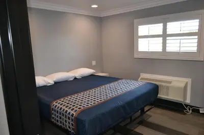 a bed in a room with a window and a bed sidx sidx sidx at Bell Gardens Inn Los Angeles - Bell Gardens in Bell Gardens