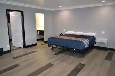 a bedroom with a bed in a room with wooden floors at Bell Gardens Inn Los Angeles - Bell Gardens in Bell Gardens